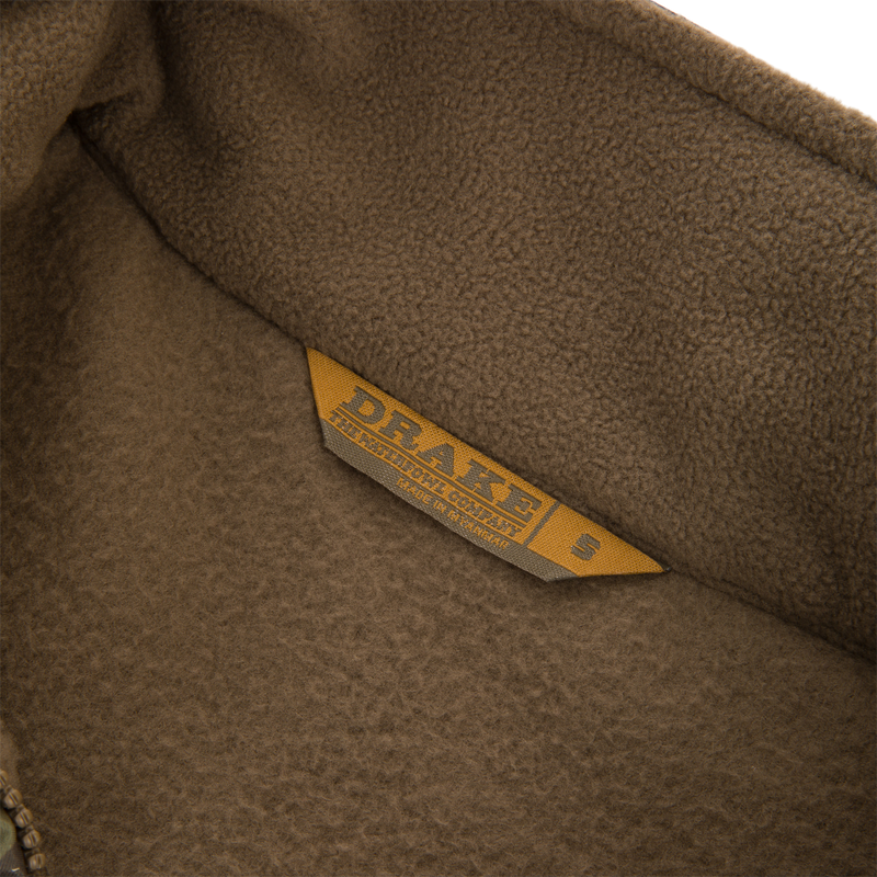 MST Eqwader Vest close-up showing detailed labels and fabric texture, highlighting waterproof upper materials and breathable fleece lower body for hunting versatility.