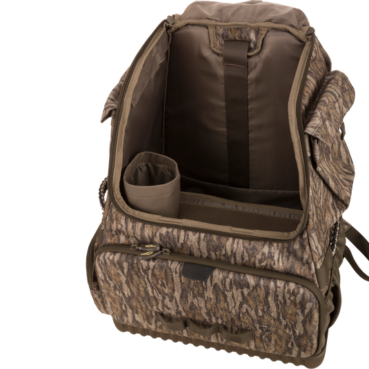 Tree Hugger Timber Pack with open main compartment showing padded dividers, cylindrical insert, various pockets, and exterior zippered front pocket for organized hunting gear storage.