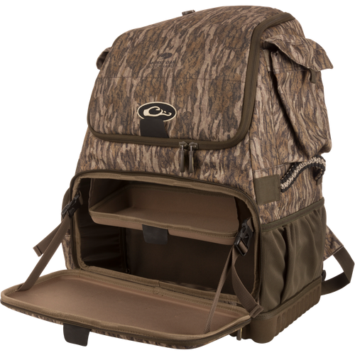 Tree Hugger Timber Pack with Mossy Oak Bottomland print, unzipped to reveal inner shelf and compartments, molded base, side pockets, paracord handles, and detachable strap.