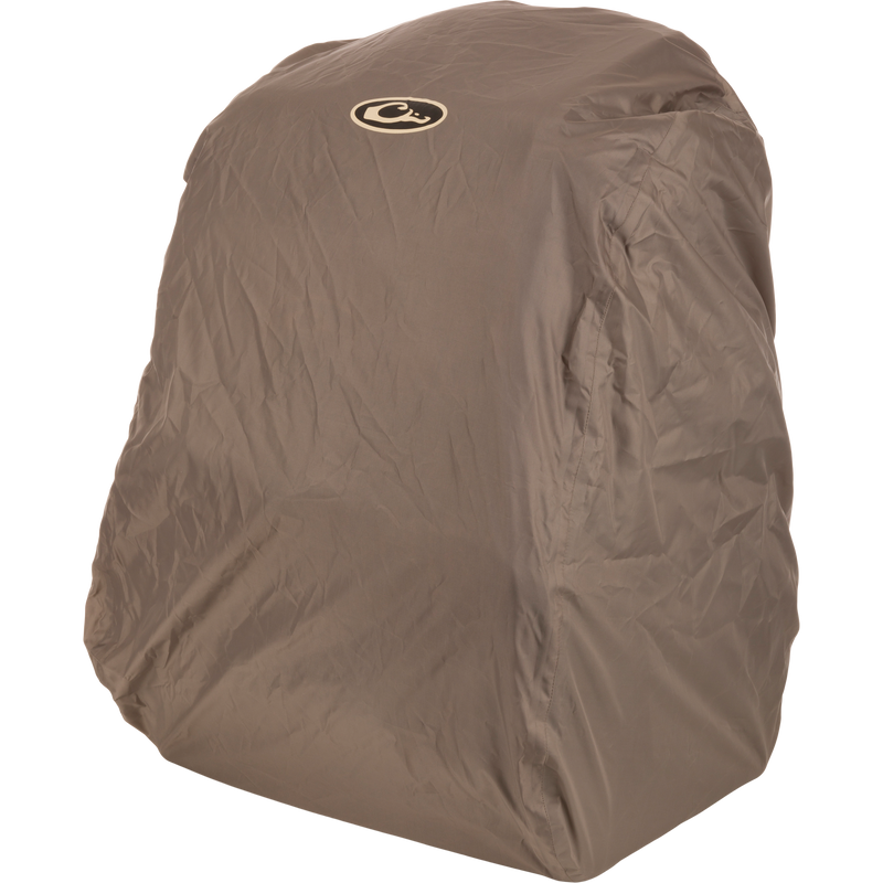 Tree Hugger Timber Pack encased in a khaki water-resistant cover with a circular logo on top, showcasing its rugged design for efficient hunting gear storage.