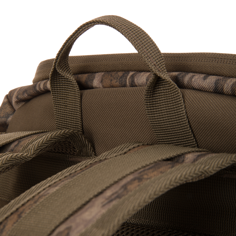 Drake Day Pack's top view with camo-patterned handle and padded shoulder straps, highlighting rugged design for hunting adventures and outdoor durability.