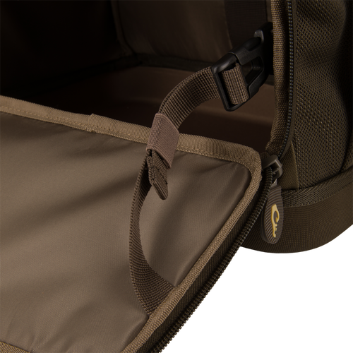 Interior of Tree Hugger Timber Day Pack, showing durable webbing, adjustable strap with buckle, and zipper pull, highlighting rugged construction for outdoor excursions.