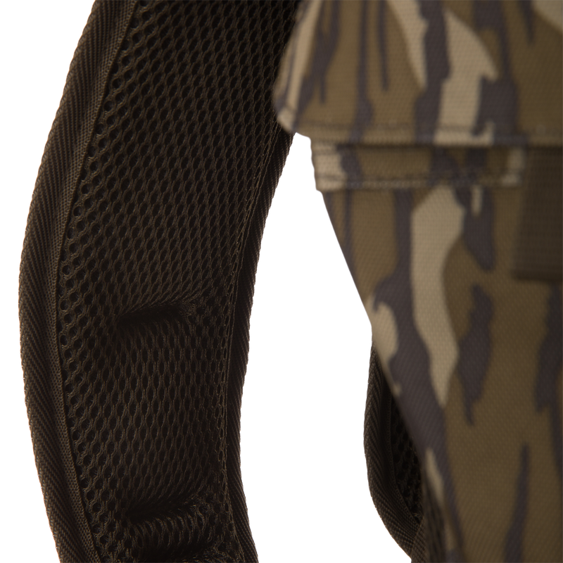Close-up of Tree Hugger Timber Day Pack's padded, mesh-covered shoulder strap, showcasing its camouflage fabric, designed for durability and easy gear access during outdoor adventures.