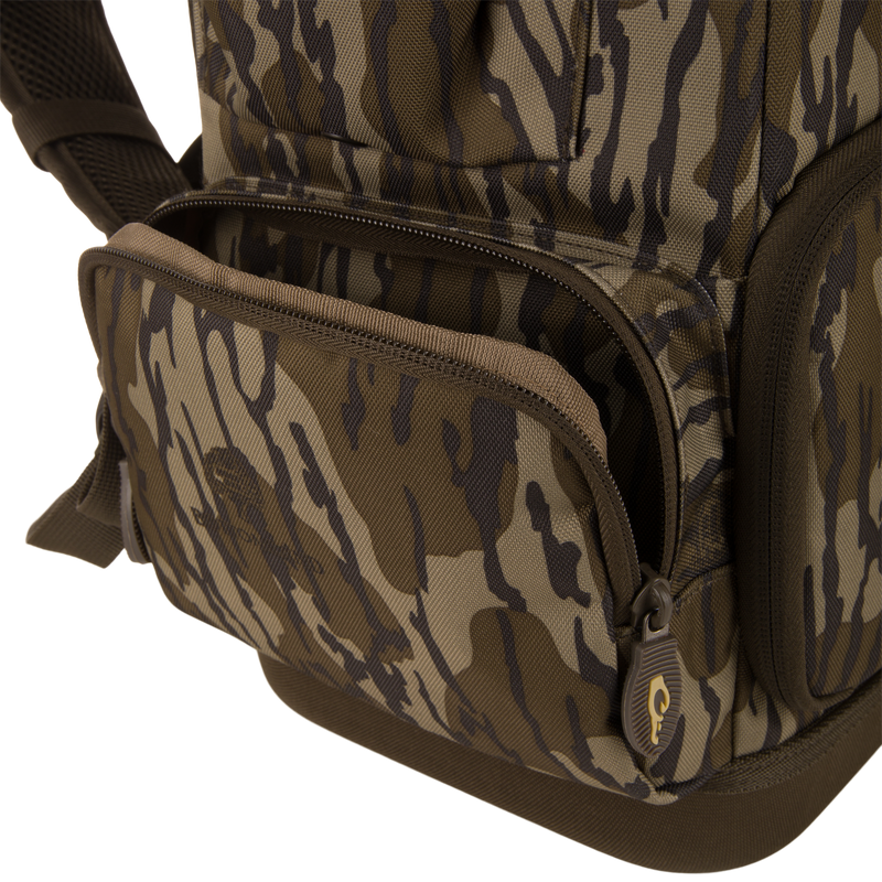Tree Hugger Timber Day Pack close-up shows camo design, front zippered pocket, main compartment zipper, and padded shoulder strap, highlighting its rugged, water-resistant features.