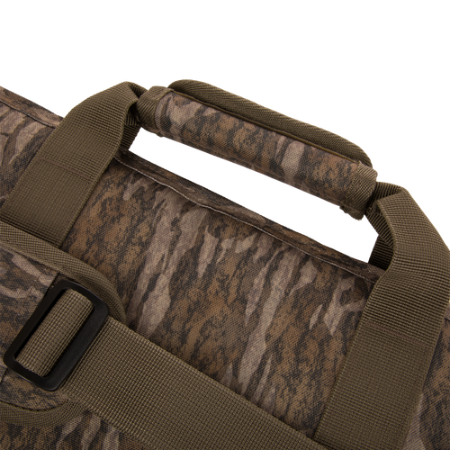 The Migrator Gun Case features a camouflage design with olive-drab straps and a padded handle, crafted for durability and waterproof protection during hunting trips.