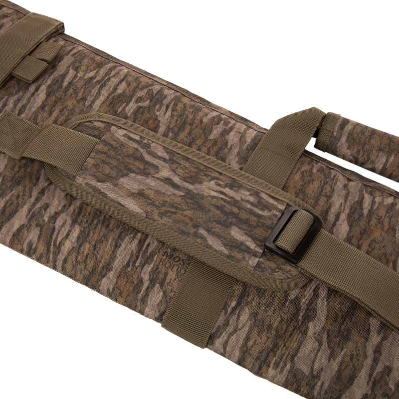 Migrator Gun Case in camo fabric with shoulder strap and handles, featuring durable polyester construction, waterproof PVC backing, and protective EPE foam padding for firearm transport.