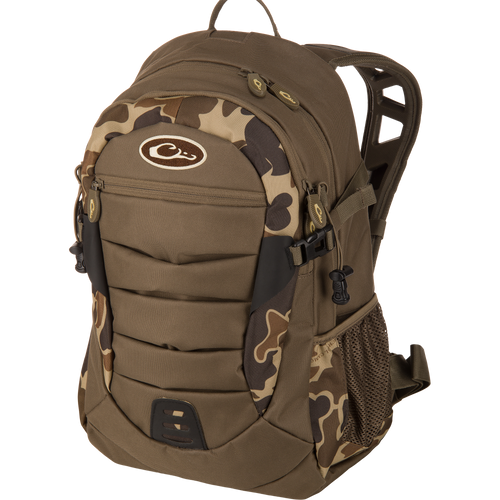 Drake Daypack in camouflage, featuring padded straps, multiple compartments, compression straps, molded front panel, and mesh side pocket, ideal for versatile outdoor use.