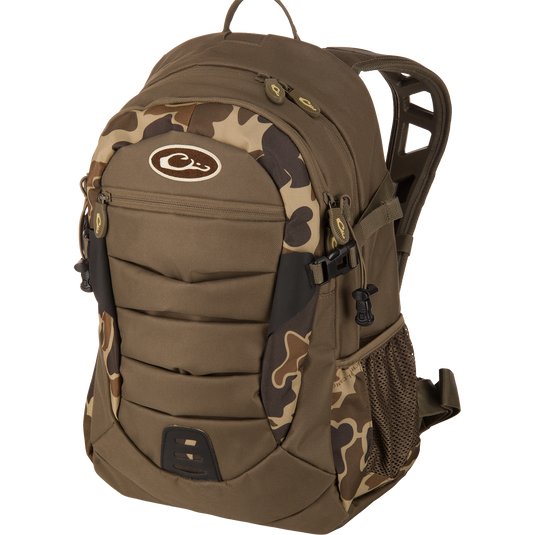 Drake Daypack in camouflage, featuring padded straps, multiple compartments, compression straps, molded front panel, and mesh side pocket, ideal for versatile outdoor use.