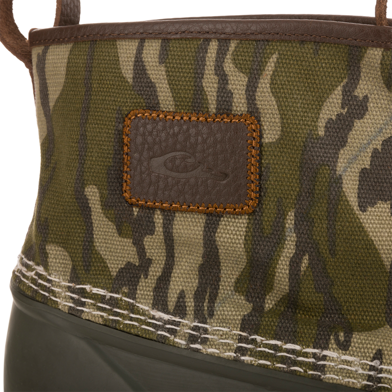 Throwback 80 Waxed Canvas Slip On Duck Boot with camo canvas upper, green rubber lower, leather patch, and heavy stitching, ideal for hunting and outdoor activities.