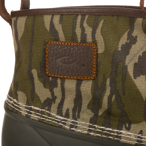 Throwback 80 Waxed Canvas Slip On Duck Boot with camo canvas upper, green rubber lower, leather patch, and heavy stitching, ideal for hunting and outdoor activities.