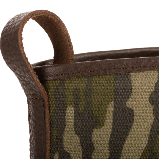 Close-up of Throwback 80 Waxed Canvas Slip On Duck Boot's camo-patterned canvas with brown leather trim and pull-loop, showcasing its rugged, durable design.