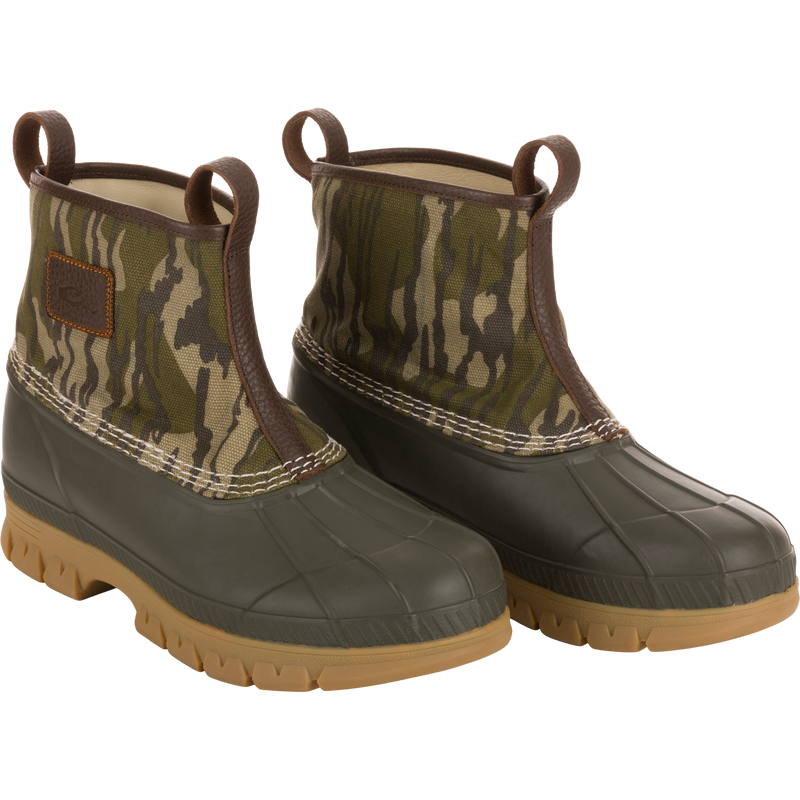 Throwback 80 Waxed Canvas Slip On Duck Boot, featuring camo-patterned canvas upper, olive-green waterproof rubber bottom, and premium leather lining for comfort and durability.