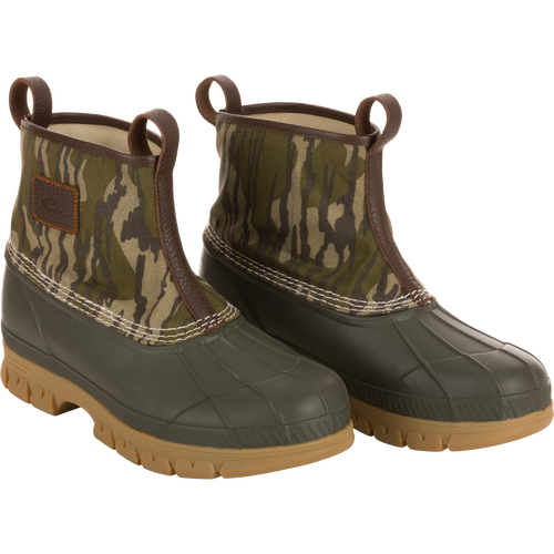 Throwback 80 Waxed Canvas Slip On Duck Boot, featuring camo-patterned canvas upper, olive-green waterproof rubber bottom, and premium leather lining for comfort and durability.