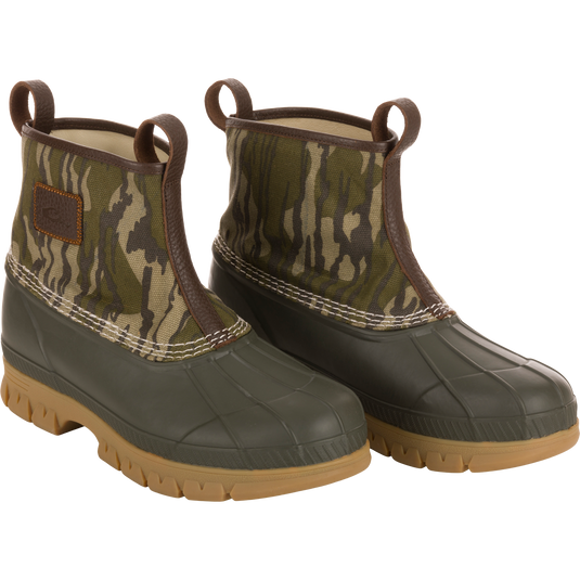 Throwback 80 Waxed Canvas Slip On Duck Boot, featuring camo-patterned canvas upper, olive-green waterproof rubber bottom, and premium leather lining for comfort and durability.