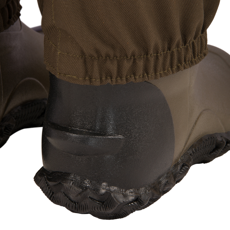 Close-up of the Hardline Insulated Breathable Wader's black molded rubber heel and sole, showcasing the durable waterproof design and cinched fabric gaiter for outdoor protection.