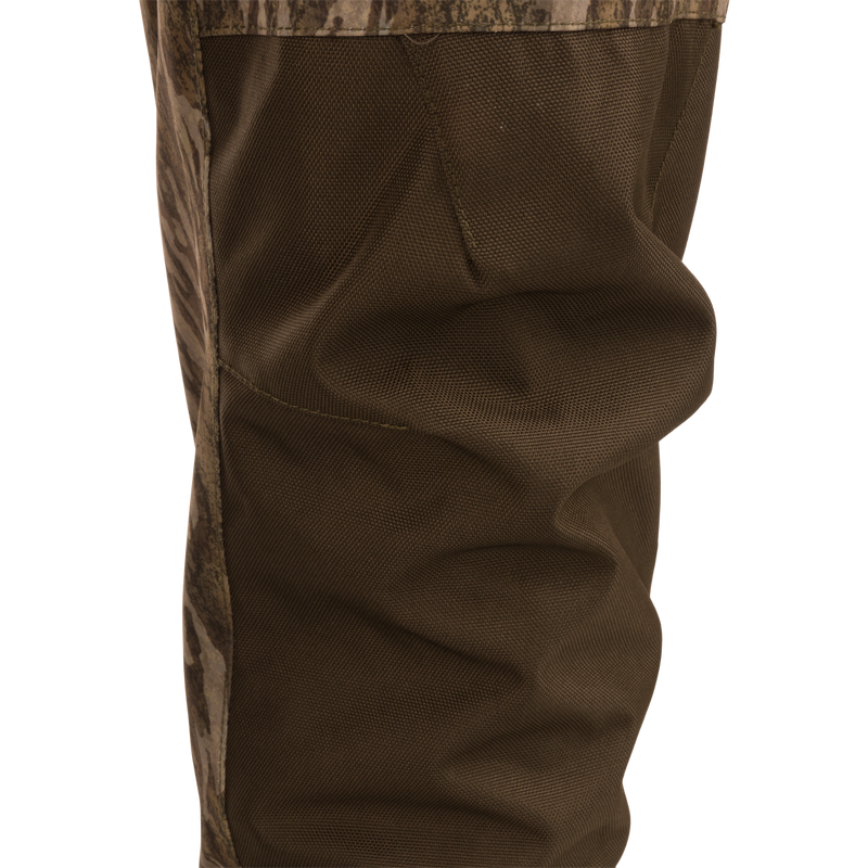 Close-up of the Hardline Insulated Breathable Wader's reinforced knee panel, showing durable stitching and camo trim for enhanced articulation and protection in rugged outdoor conditions.