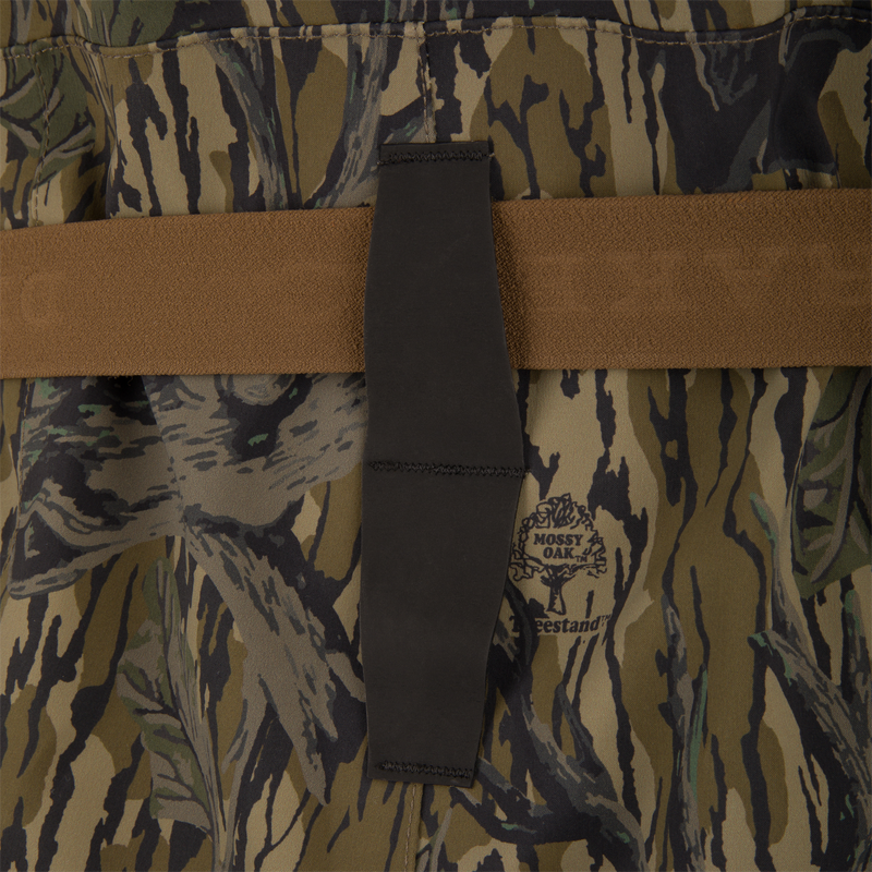Close-up of BMF1600 Kevlar Wader with Primaloft, featuring Mossy Oak camo fabric, brown webbing strap, and black elastic tab, showcasing advanced durability and water resistance.