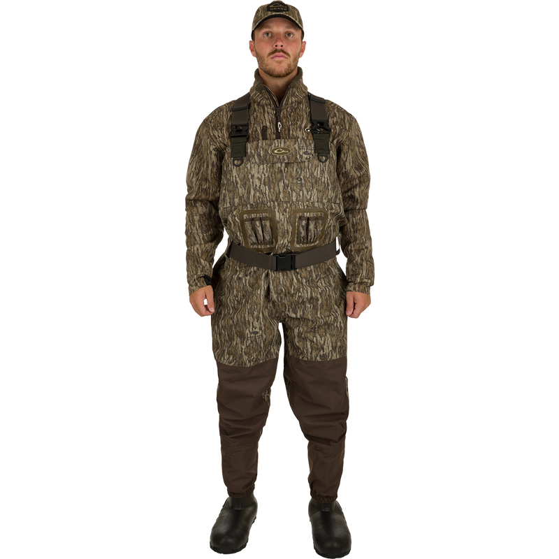 A man in camouflage uniform wearing Insulated Guardian Elite Vanguard Breathable Waders, standing confidently.