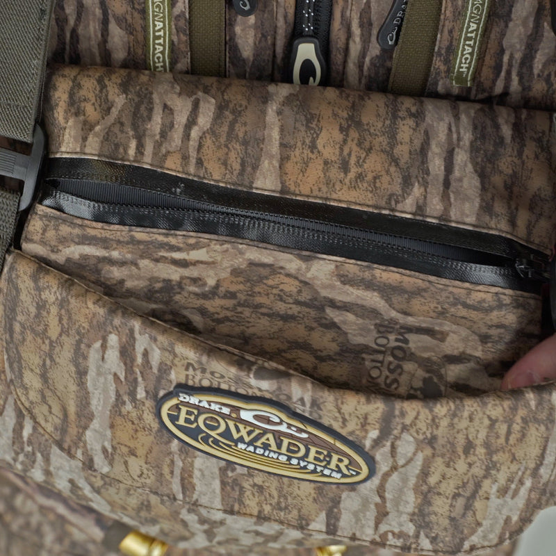 A person's hand holding a Drake Insulated Breathable Chest Wader with Sewn-in Liner, showcasing HD2 material and LokDown insulation for warmth and protection.