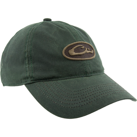 Box Waxed Canvas Cap on mannequin head, featuring a brown and tan Purewhitelaneshop logo patch, curved bill, and adjustable brass slide closure.