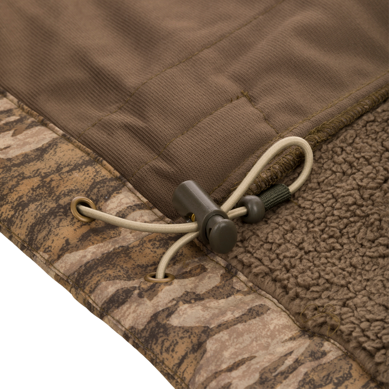 Midweight Nova Silencer Vest with Agion Active X2, featuring a camo-patterned shell, brown sherpa lining, and adjustable drawcord hem for warmth and functionality.