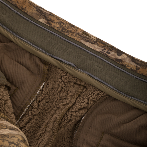 Midweight Nova Silencer Pant with Scent Control featuring brown sherpa lining, non-slip waistband, and camouflage shell, ideal for hunting with anti-odor and water-resistant features.