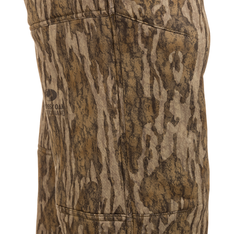 Midweight Nova Silencer Pant with Scent Control featuring Mossy Oak Bottomland pattern, showcasing stitching, pocket outline, and logo, designed for odor protection and water resistance.