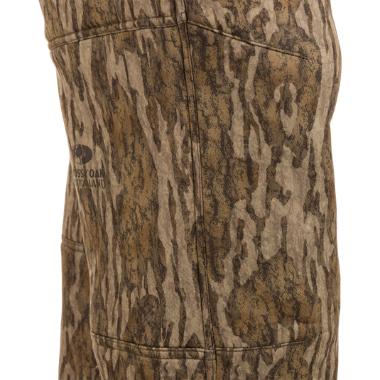 Midweight Nova Silencer Pant with Scent Control featuring Mossy Oak Bottomland pattern, showcasing stitching, pocket outline, and logo, designed for odor protection and water resistance.
