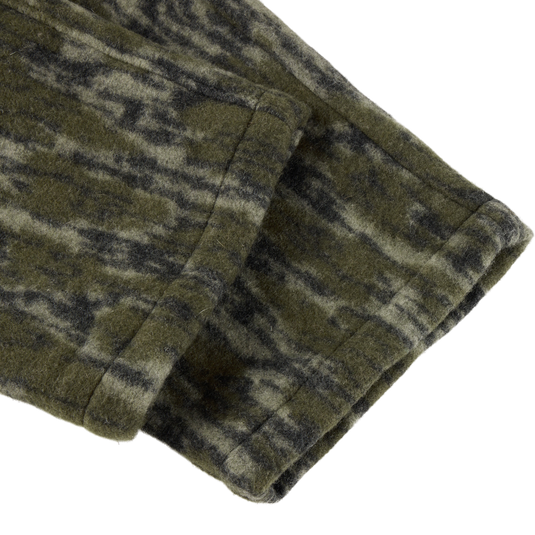 Close-up of the Midweight Hydrowool Softshell Pant’s green-and-black mottled hem, showcasing durable, windproof, waterproof fabric with stretch for outdoor performance.