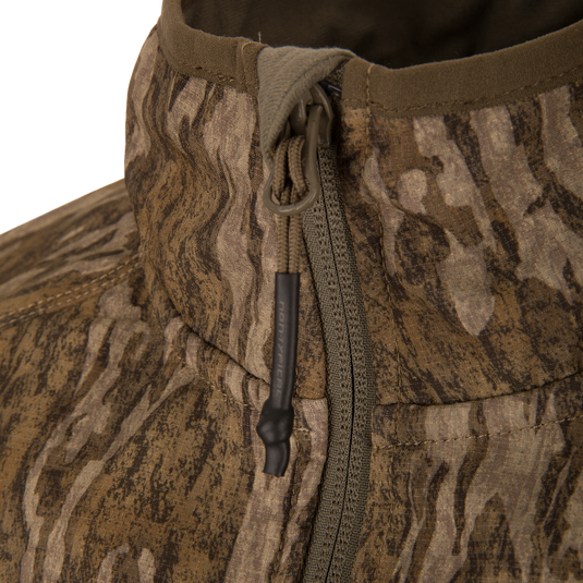 Close-up of the Non-Typical SWT Hybrid Half Zip showcasing its wood-grain camo pattern, zippered front with paracord pull tab, and detailed stitching.