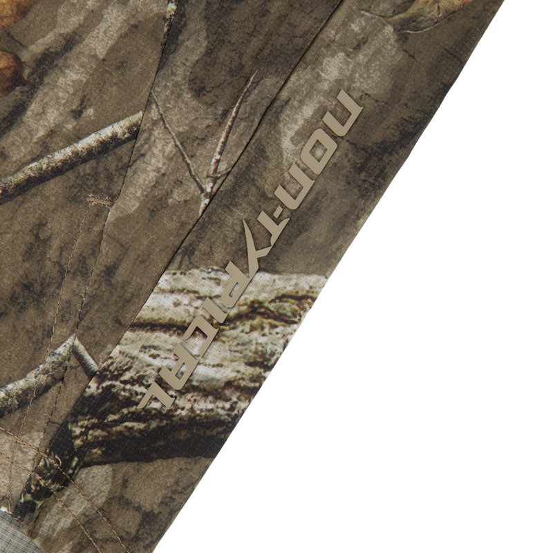 Camouflage-patterned fabric of the Non-Typical Lightweight SWT Half Zip Pullover with Scent Control, showcasing stitching and blocky stencil-style logo, highlighting durability and ergonomic design.