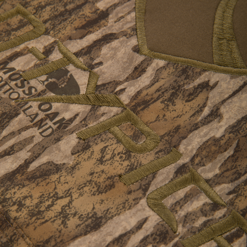 Youth Non-Typical Performance Hoodie with Agion Active featuring Mossy Oak Bottomland camo pattern and olive-green embroidery, ideal for hunting with durable, stretchy fabric.