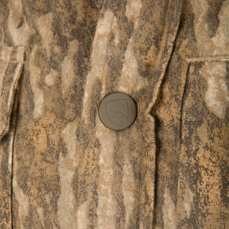 Close-up of Non-Typical Campfire Hoodie showcasing textured camo fabric and a snap button with embossed stag logo, highlighting its durable, functional design.