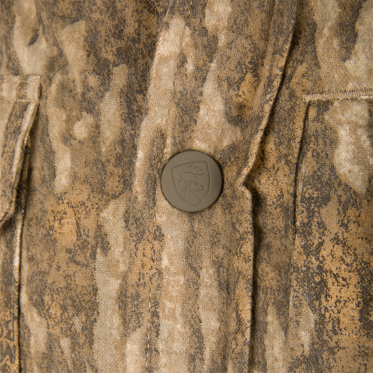 Close-up of Non-Typical Campfire Hoodie showcasing textured camo fabric and a snap button with embossed stag logo, highlighting its durable, functional design.