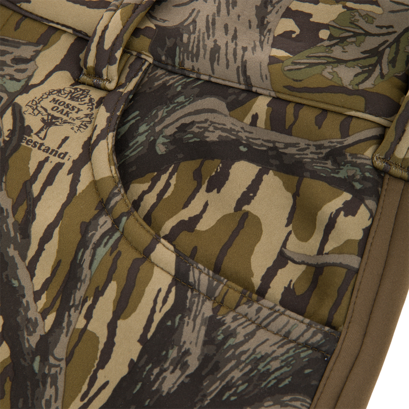 Close-up of the Non-Typical Endurance Pant's camo-patterned pocket with Mossy Oak print, showcasing durable stitching and webbing typical of high-quality hunting gear.