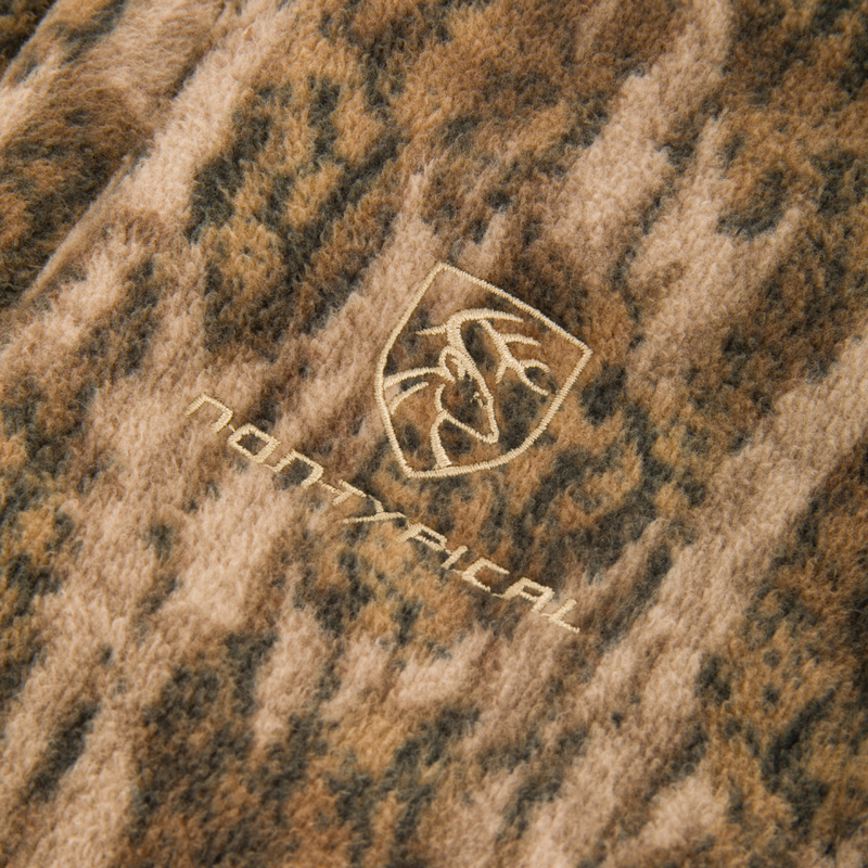 Close-up of the Non-Typical Windproof Layering Vest featuring camo-patterned fleece with a Non Typical logo, showcasing its windproof, water-resistant design and convenient pockets.