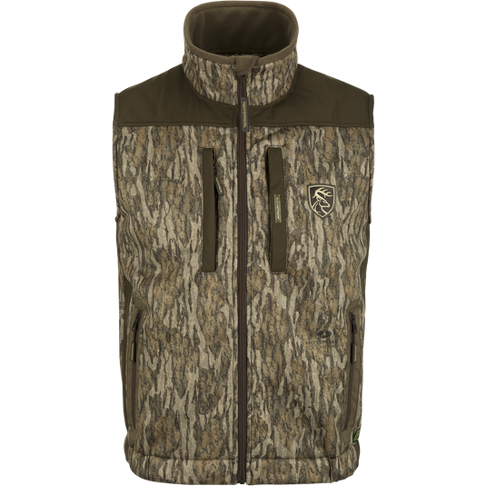 Standstill Windproof Vest with Agion Active XL®: A camouflage jacket with a logo of a deer, perfect for mid-to-late season hunting. Features include scent control technology, zippered pockets, and a safety harness pass-through opening. Ideal for layering or wearing over a mid-layer.