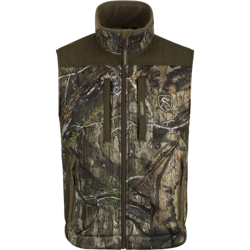 A Standstill Windproof Vest with Agion Active XL® featuring a camouflage pattern and logo of a deer. Perfect for mid-to-late season hunting, it offers soft, quiet, and durable fabric. Ideal for layering or wearing over a mid-layer.