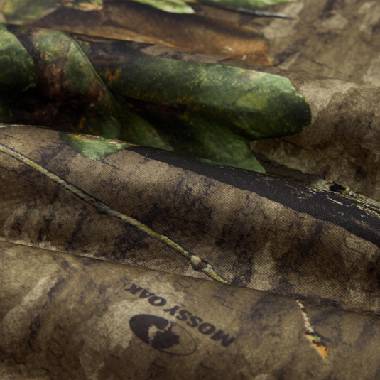 Close-up of folded Non-Typical Silencer Hoodie with Agion Active X2, showcasing Mossy Oak camouflage pattern, highlighting its breathable polyester and high-pile sherpa fleece composition.