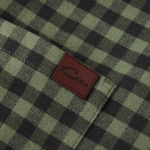 Close-up of the Autumn Flannel Shirt pocket, featuring a burgundy leather patch with logo, highlighting its brushed cotton twill fabric and outdoor-ready design.