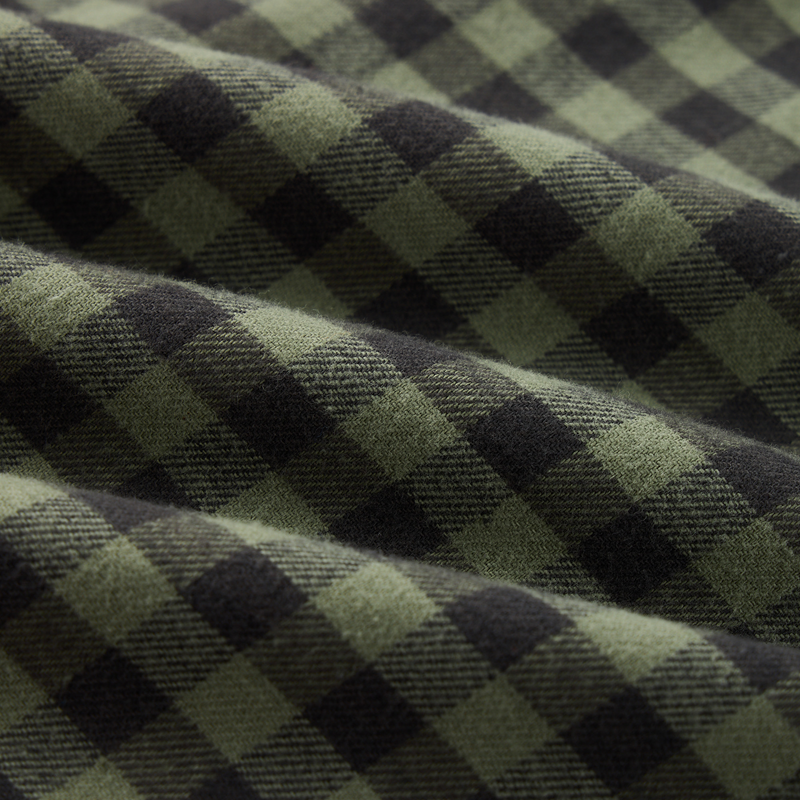 Autumn Flannel Shirt with a green and dark checkered pattern, soft folds, featuring a button-down collar, chest pocket, and sculpted hem for versatile wear.