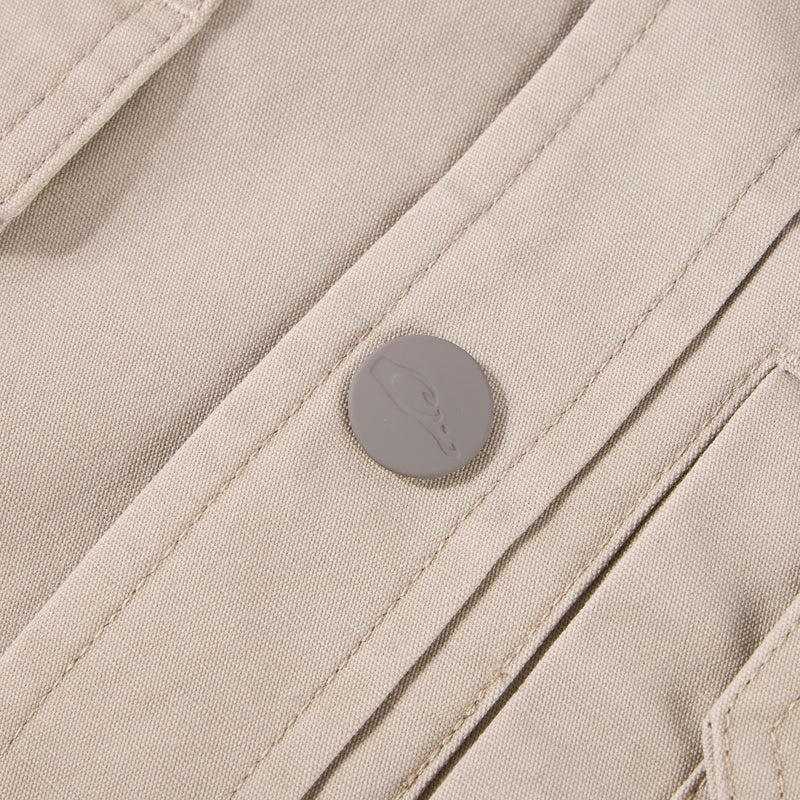 Close-up of Campfire Canvas Shirt Jac Hoodie, showcasing beige canvas fabric, stitched seams, and embossed snap-button detail, emphasizing its durable, workwear-inspired design.
