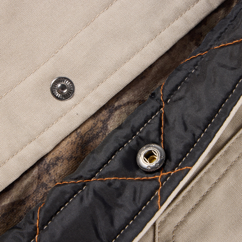 Snap-button closure of the Campfire Canvas Shirt Jac Hoodie, showcasing the durable quilted lining and versatile design, ideal for warmth and style in outdoor settings.