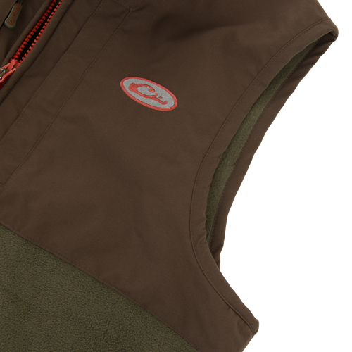 Close-up of the Drake Eqwader Vest showcasing its waterproof upper with taped seams, fleece lower body, and chest pockets designed for secure storage.