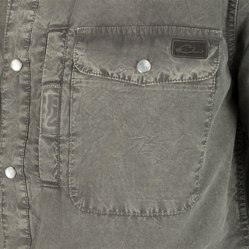 Close-up of the Cinco Ranch Western Acid Washed Short Sleeve Shirt highlighting the pocket, faux pearl snaps, and grey fabric texture.