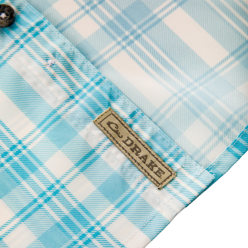 Frat Faded Plaid Button-Down Short Sleeve Shirt showcasing a blue and white plaid pattern, brown label, and stitched fabric details, ideal for active, outdoor wear.