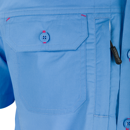Close-up of the Wingshooter Trey Solid Short Sleeve Shirt showcasing a button, zipper, and pocket details, emphasizing its stretch cotton blend and functional design.