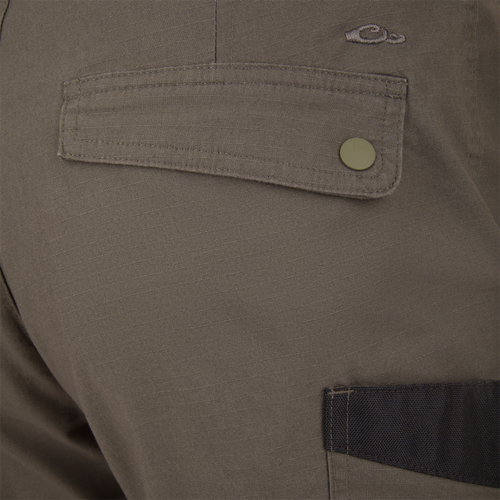 Close-up of the Drake 9-Pocket Ripstop Short, highlighting the snap-button flap pocket and contrasting black trim, showcasing durable ripstop fabric for outdoor adventures.