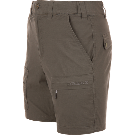Olive-green 9 Pocket Ripstop Short on mannequin, featuring multiple pockets, including zip and flap, with elastic waistband, ideal for outdoor adventures.