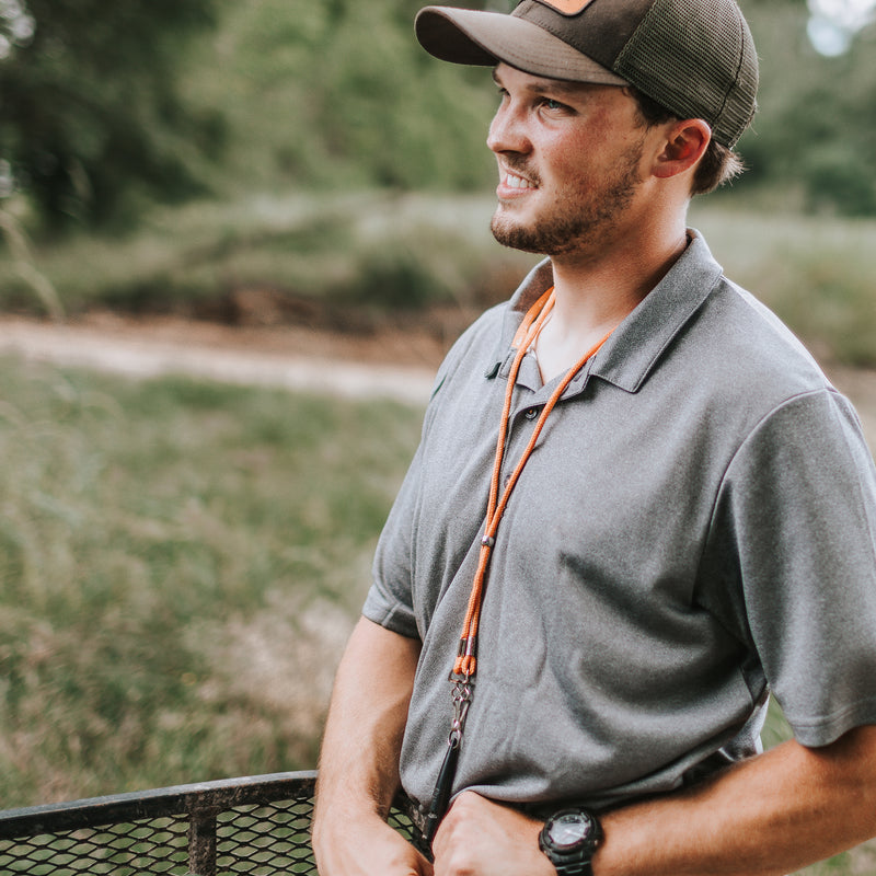 A man in a performance Heather Polo S/S with textured heather fabric, built-in stretch, and moisture-wicking properties. Ideal for outdoor activities.